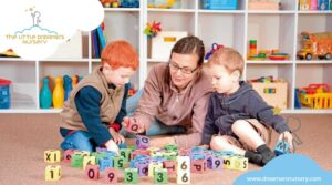 a teacher is playing alphabet cubes in nursery