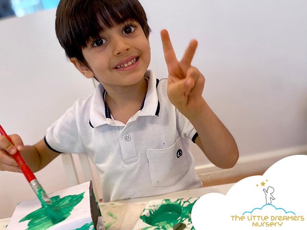 happy toddler is painting in a nursery in dubai