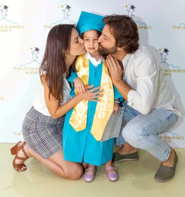 parents kissing their kids in the graduation party